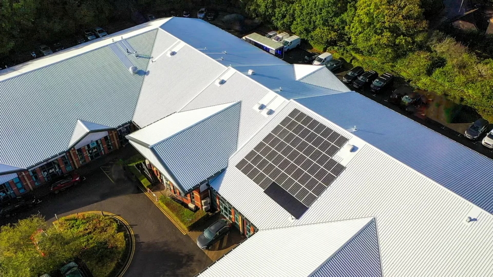 Aerial view commercial building solar panels metal roof parking