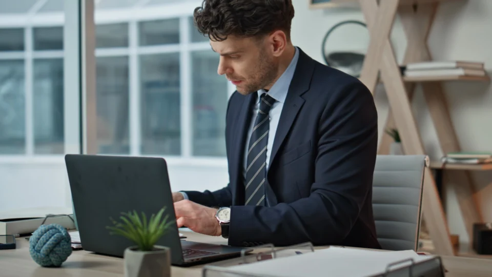 Professional businessman working on laptop at modern office desk