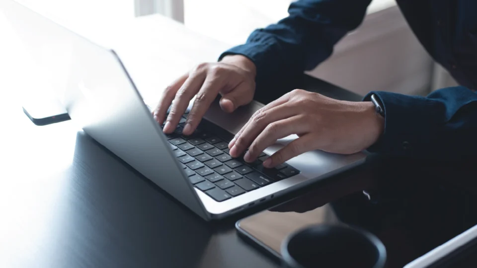 Professional using laptop keyboard for industrial manufacturing tracking work