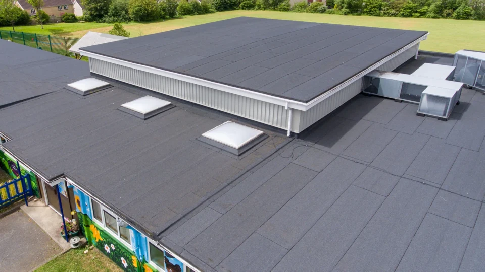 Aerial view of commercial flat roof with solar panels and HVAC units