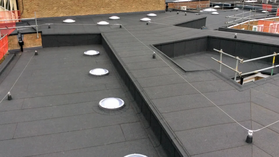 Commercial flat roof with skylights and safety railings installed