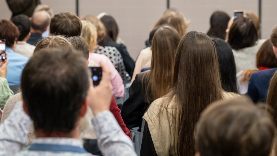 Large crowd of people gathered at professional development event indoors