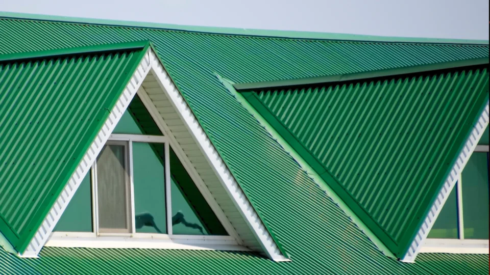 Green corrugated metal roof with white trim and skylights