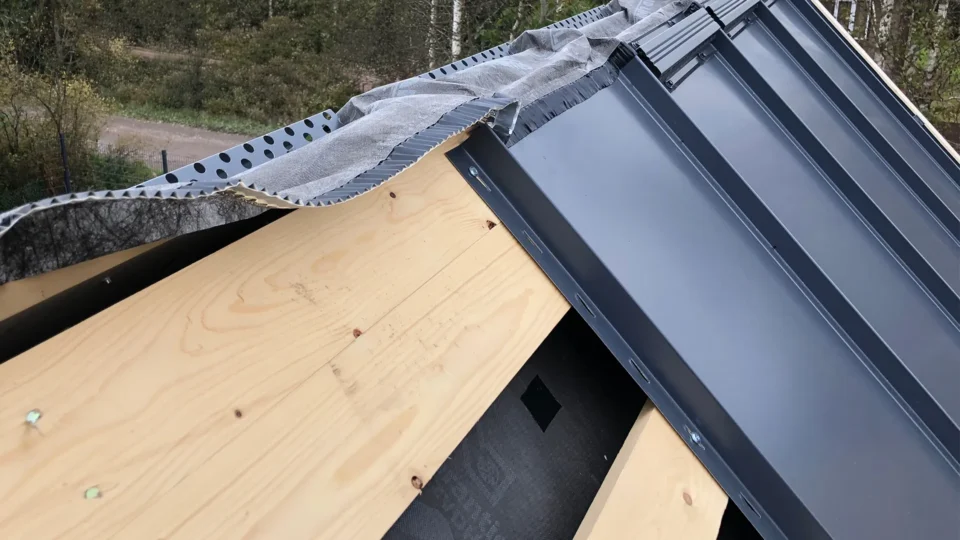 Metal roof flashing installation with wooden fascia and underlayment detail