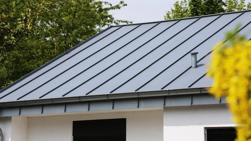Modern metal roof with standing seams on white residential building