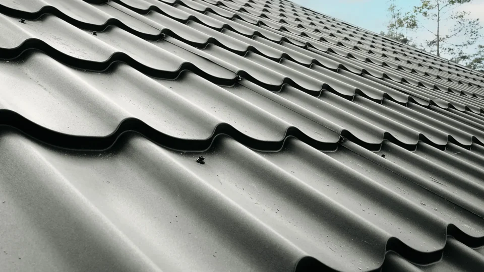Close-up view of gray wavy roof tiles with shadow details and texture.