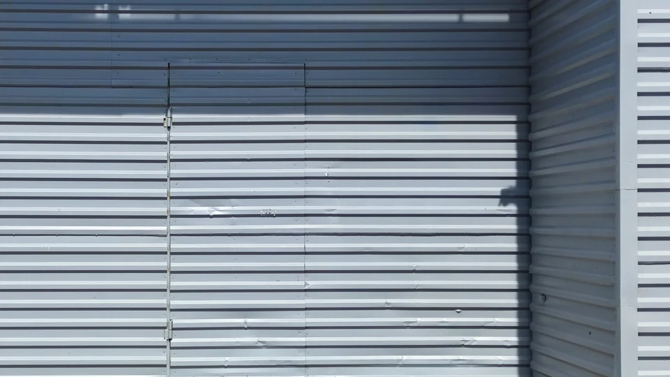 Corrugated metal wall panels with vertical seams and shadow patterns