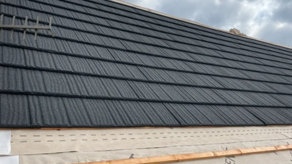 Dark slate roof tiles installed on residential building exterior