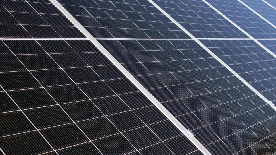 Close-up view of solar panel cells with white grid lines and texture details
