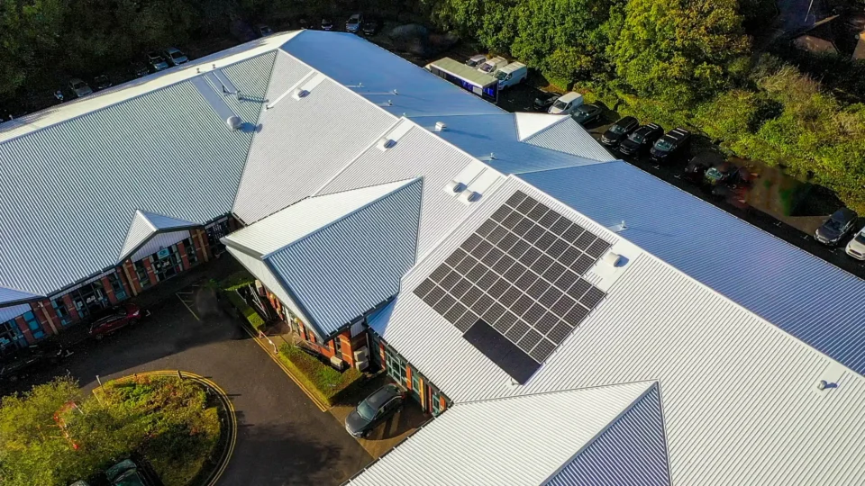 Aerial view commercial building solar panels metal roof parking