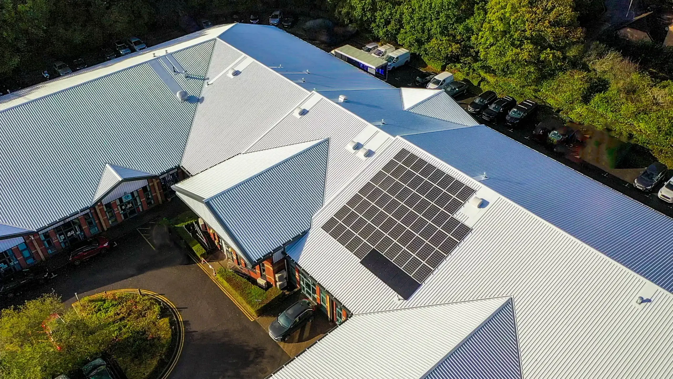 Aerial view commercial building solar panels metal roof parking