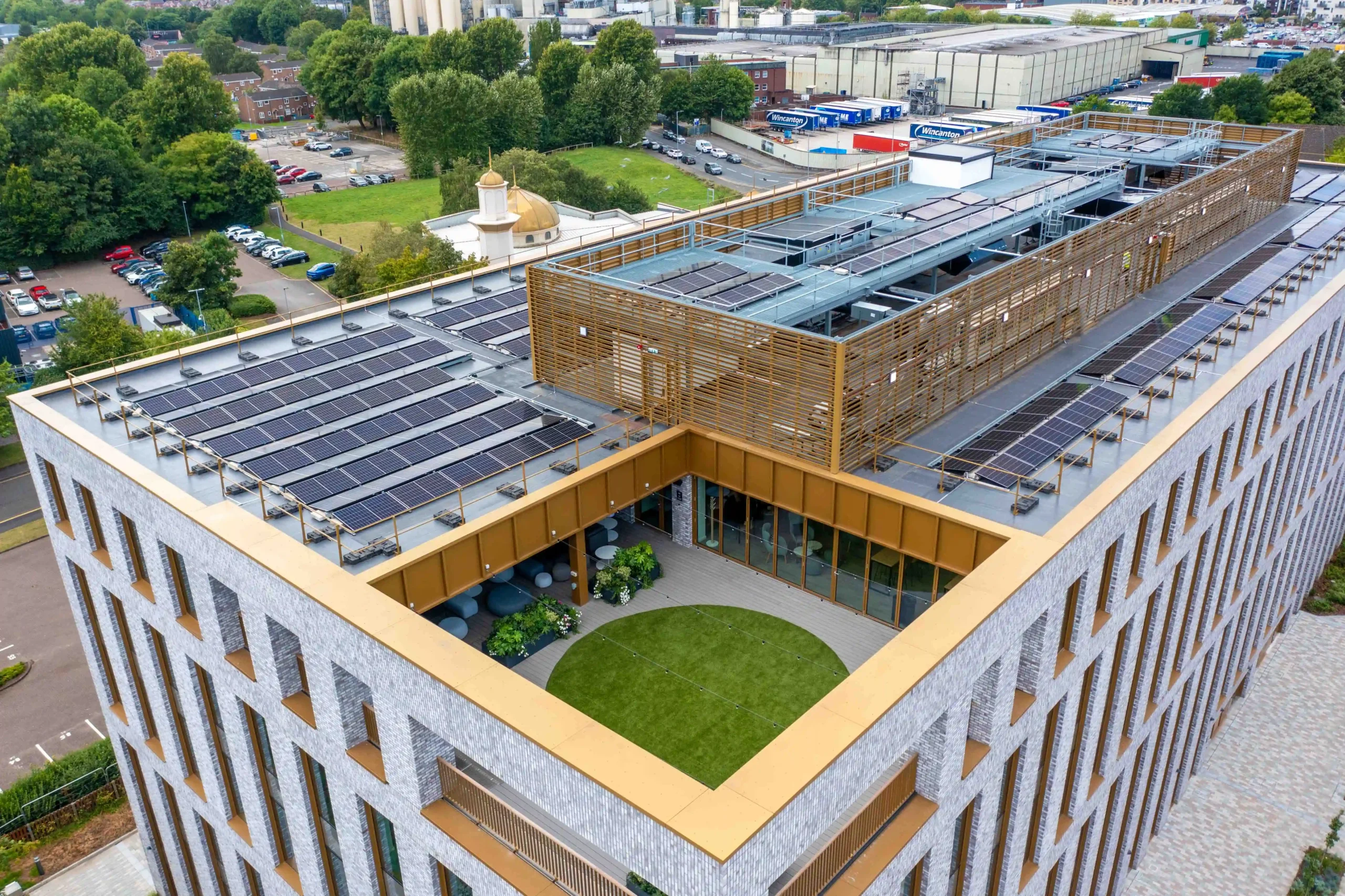 Modern building with rooftop solar panels and central courtyard garden